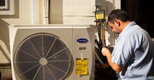 technician inspecting heat pump