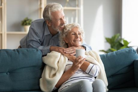 older couple together at home warm and cozy on the couch