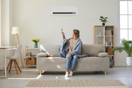 woman on couch with a blanket using her heat pump