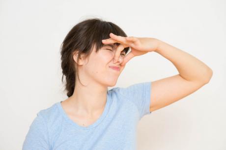 woman holding her nose because of a bad smell